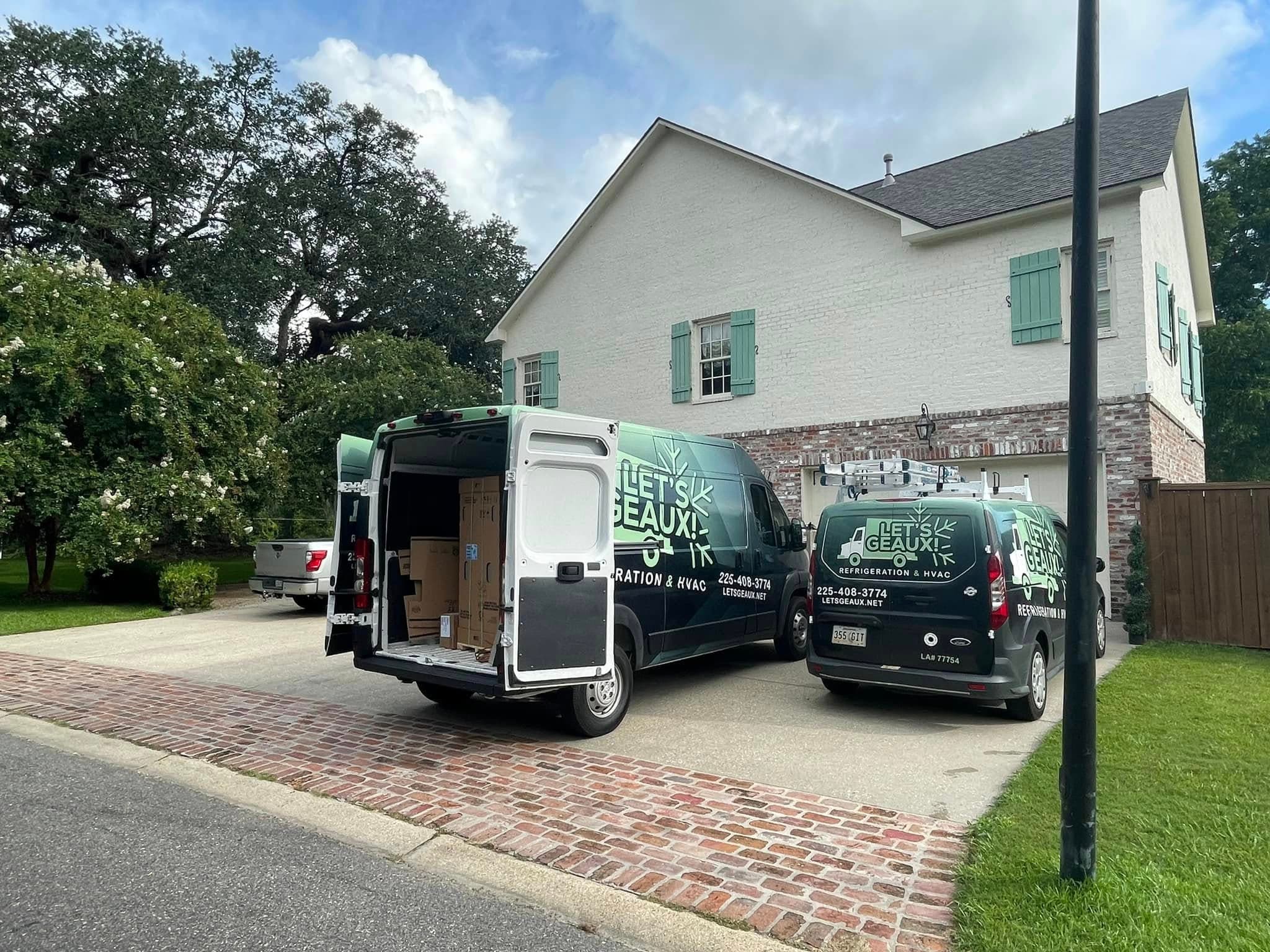 Let's Geaux service vans parked at a residential home