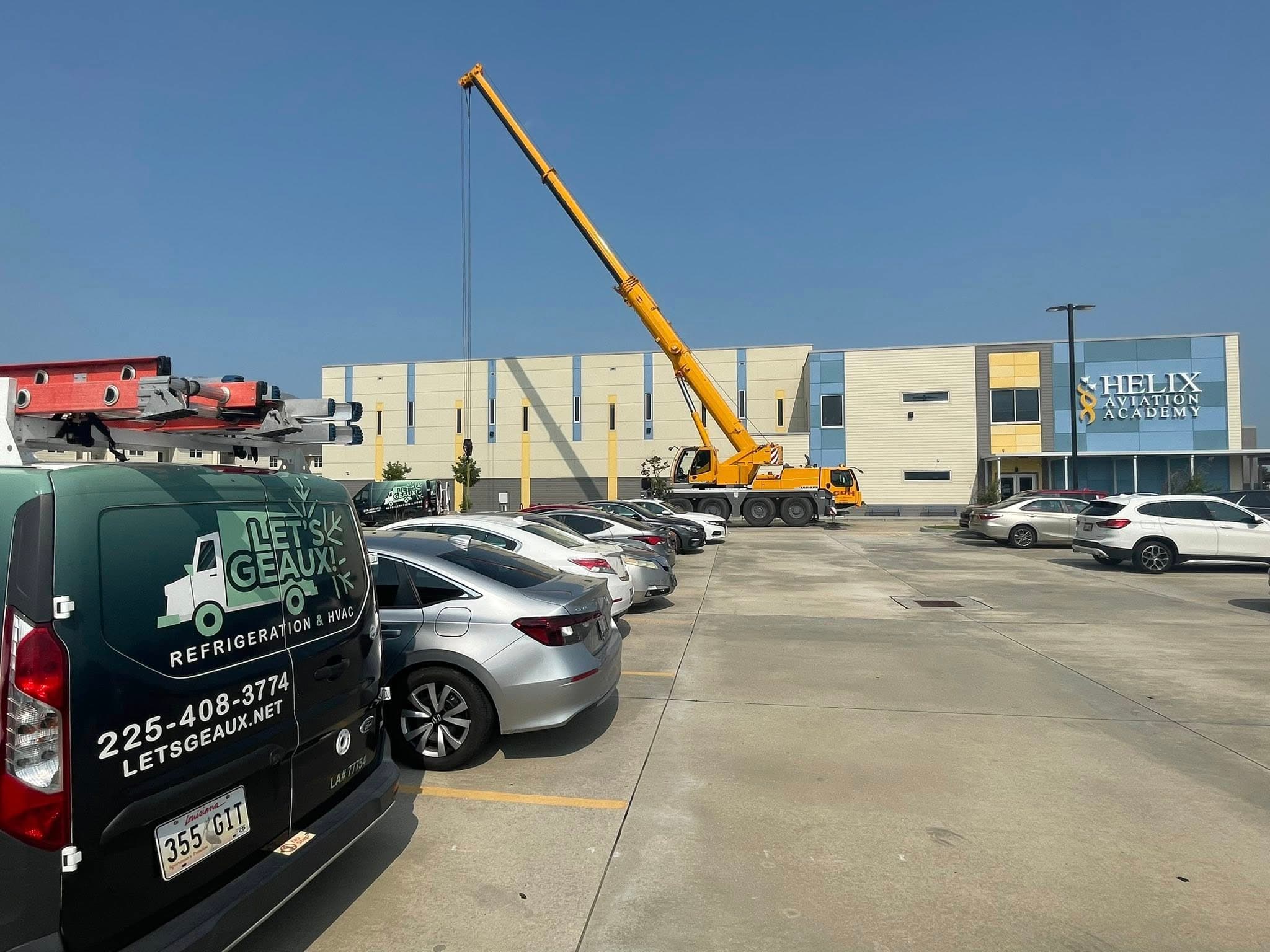 Let's Geaux service van with crane on a commercial site